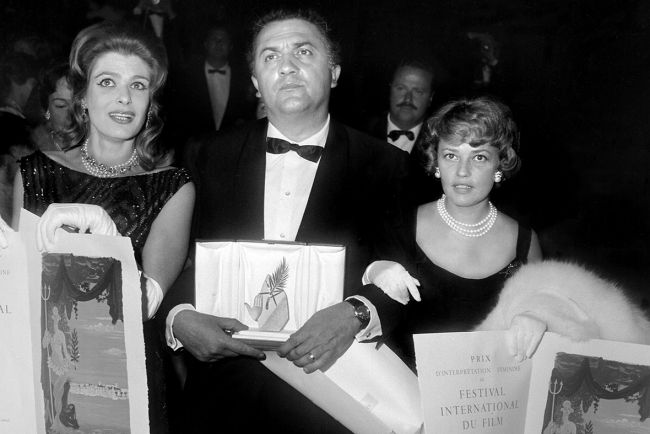 Στη φωτογραφία η Μελίνα Μερκούρη με τον Federico Fellini και την Jeanne Moreau, με την οποία μοιράστηκε το βραβείο καλύτερης ηθοποιού